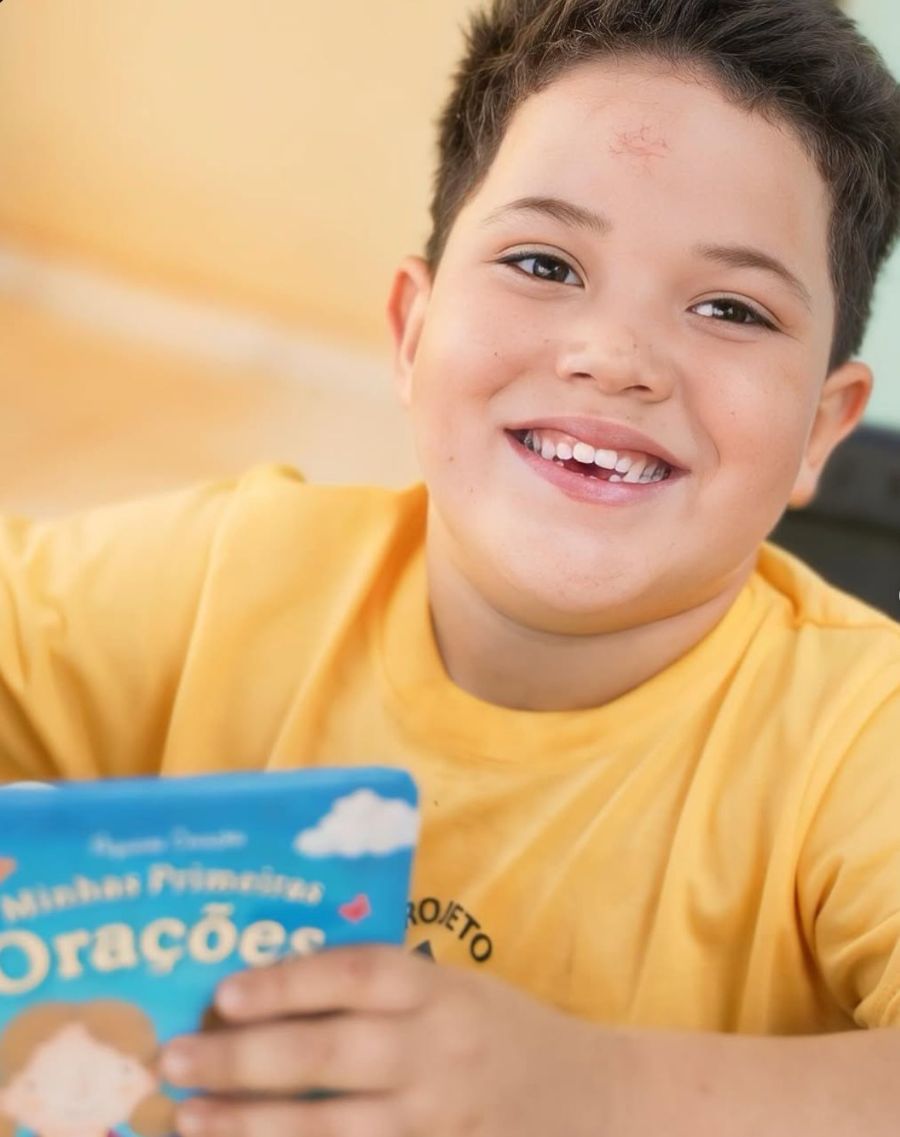 Menino sorrindo com um livro nas mãos